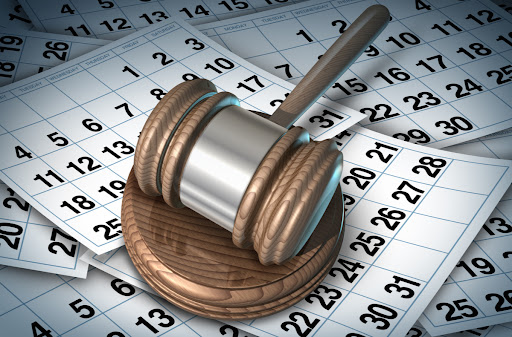 A judge's gavel resting on pages from a calendar.